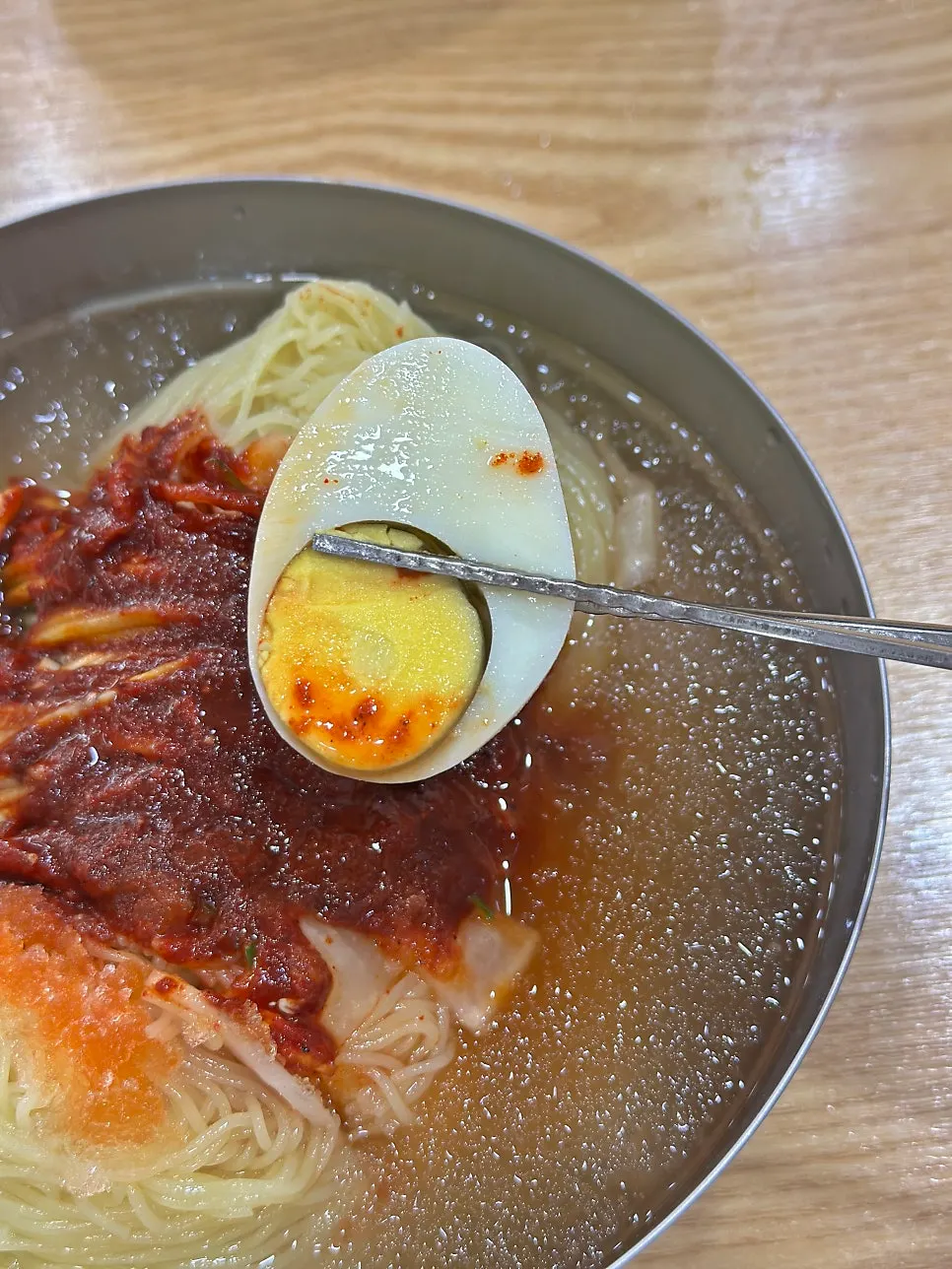 Half a boiled egg on top of the mul-milmyeon