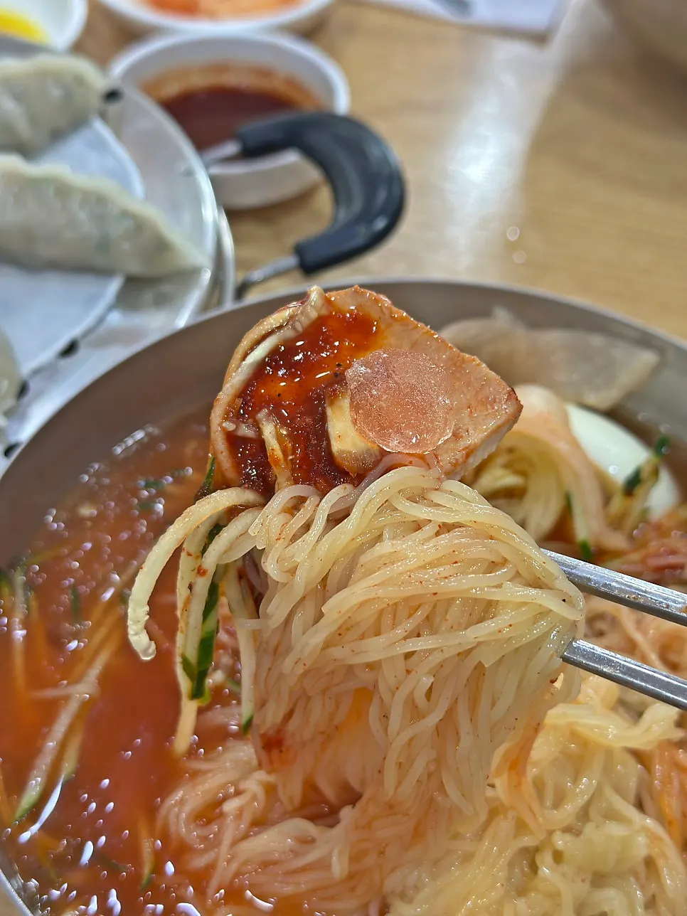 Close-up of mul-milmyeon topped with meat garnish