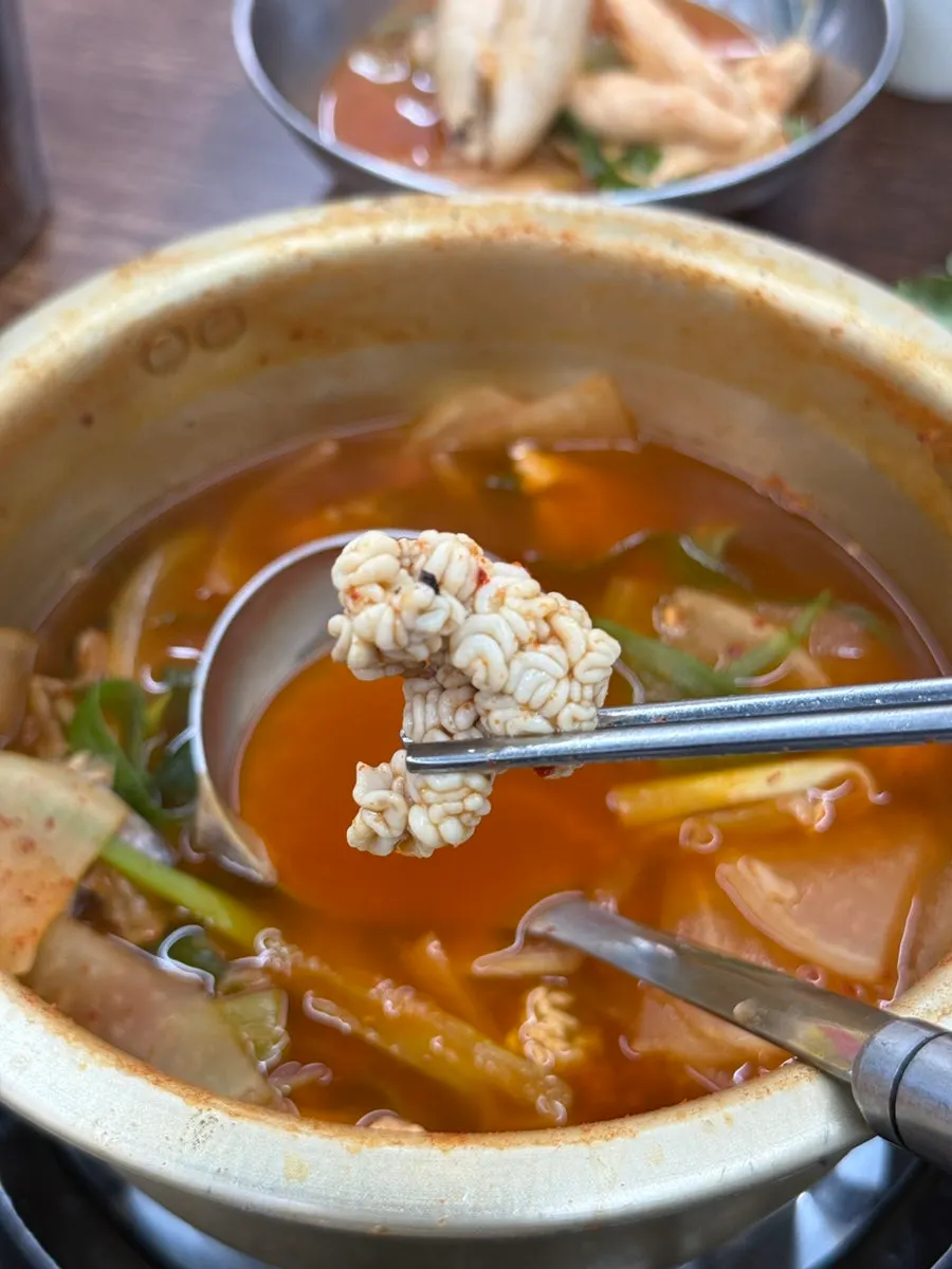 A ladle lifting thick pollack flesh from the soup