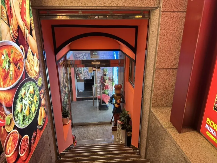 Pintu masuk restoran India menuju lantai basement