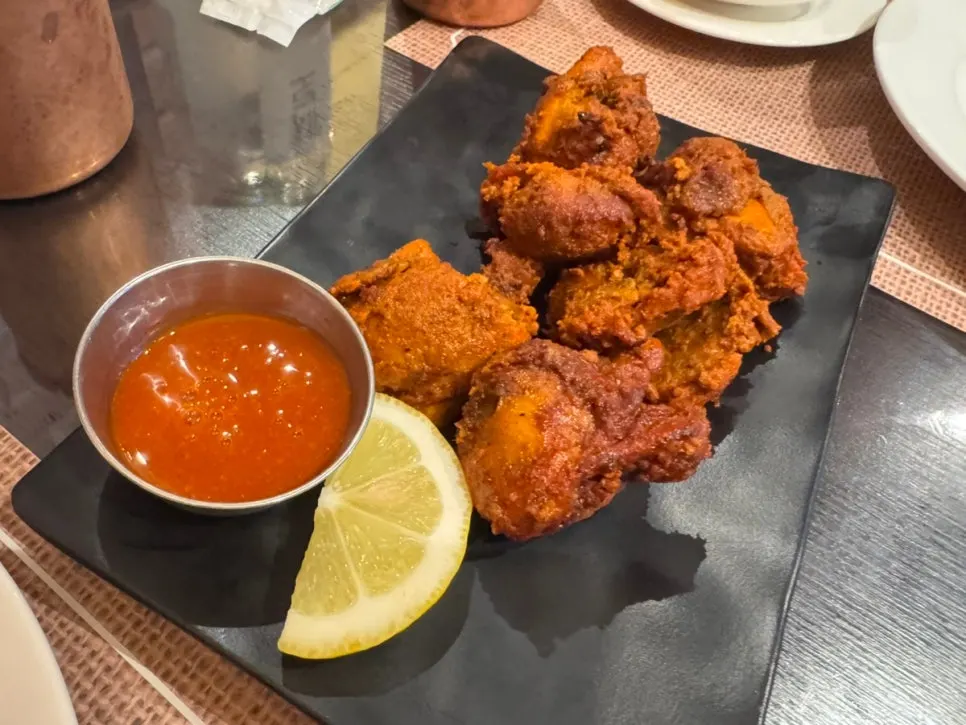 Piring berisi tandoori chicken beraroma rempah
