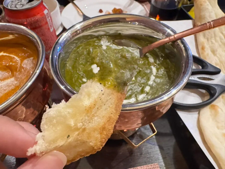 Naan yang ditumpuk banyak palak paneer di atasnya