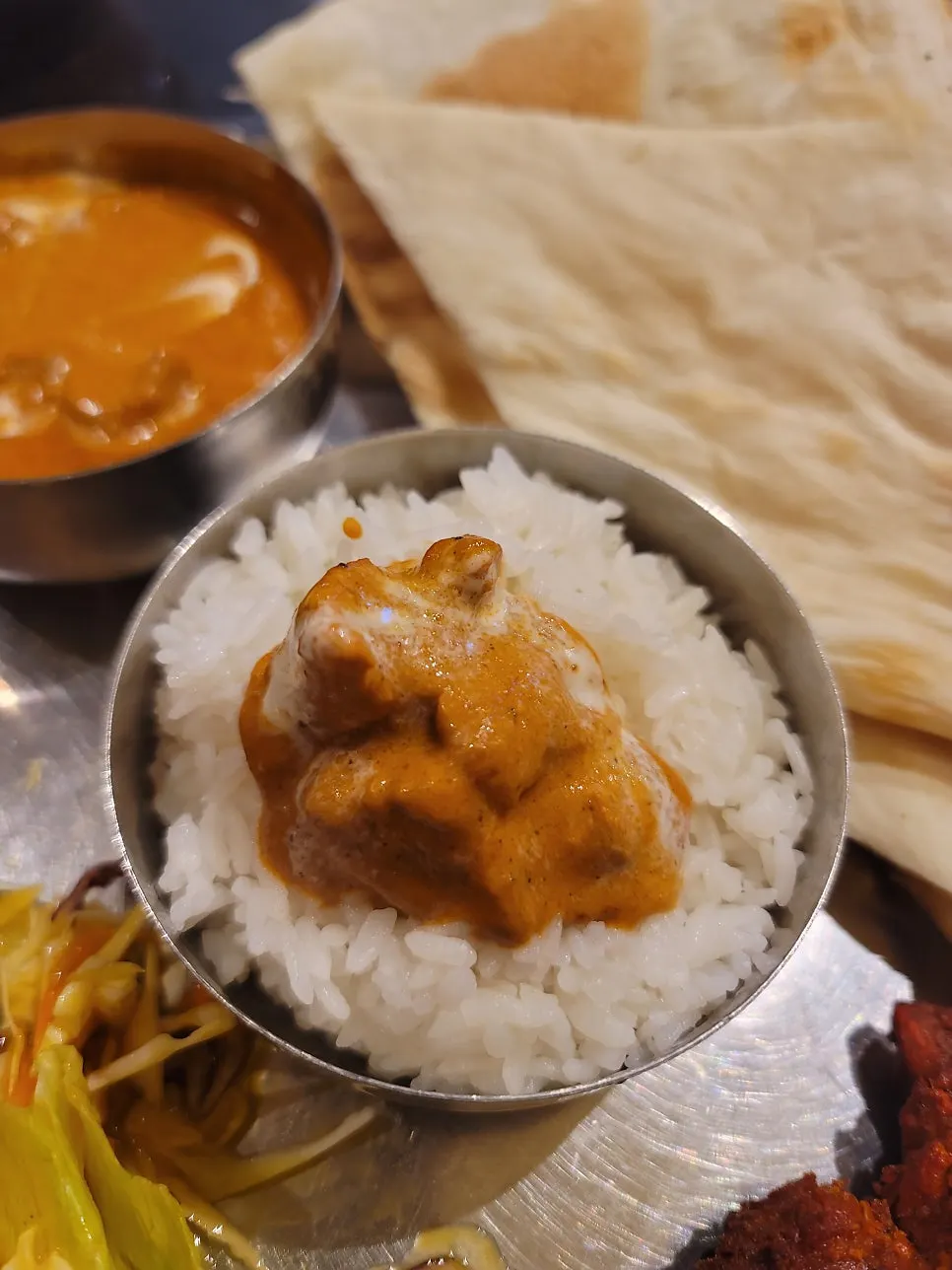 난을 찢어 치킨 마크니 커리에 찍는 모습
