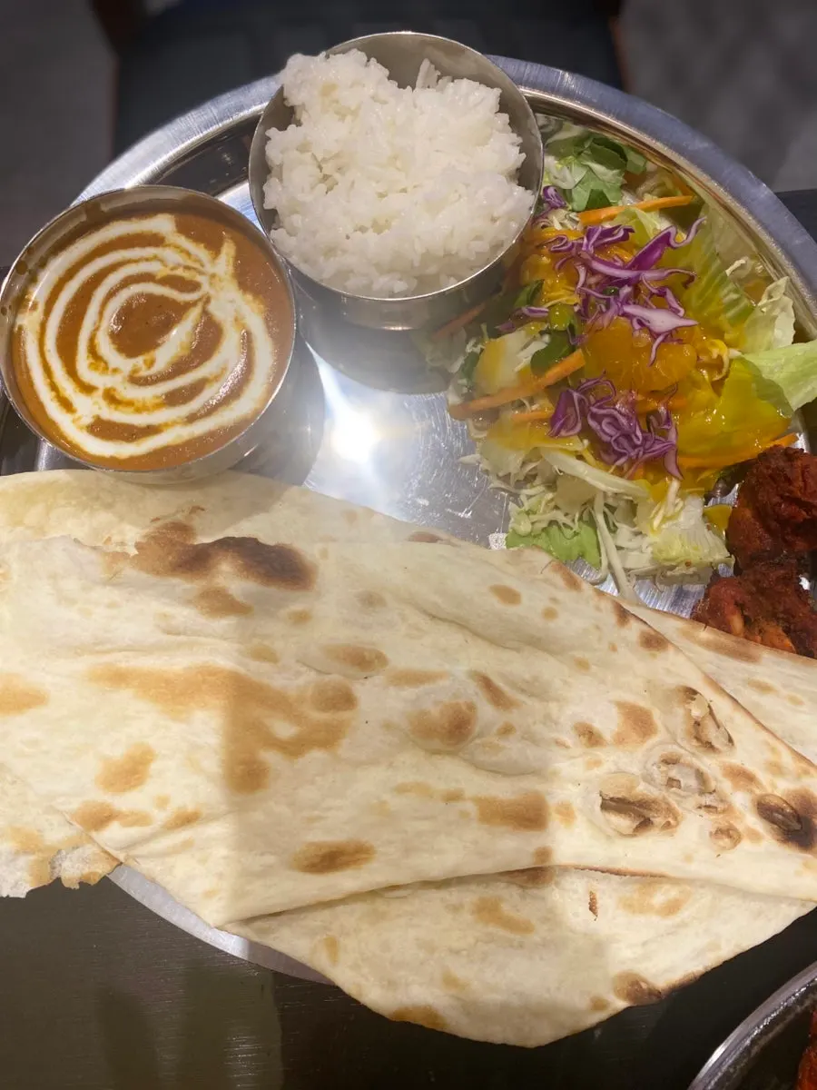 Meal with tandoori chicken, salad, and lassi