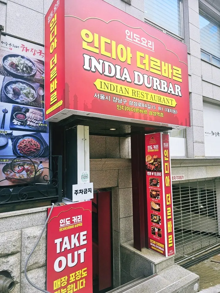 Vertical photo of a full Indian meal spread at India The Durbar Samseong Station Branch