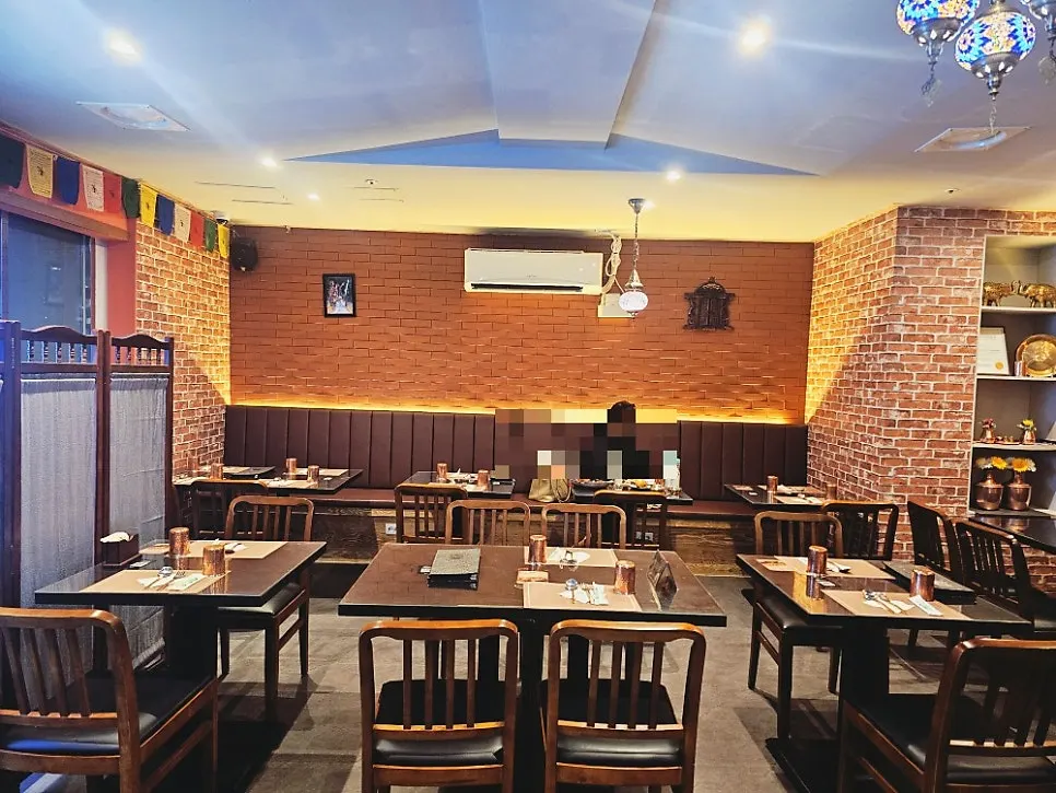 A view of the dining hall with tables at India The Durbar Samseong Station Branch