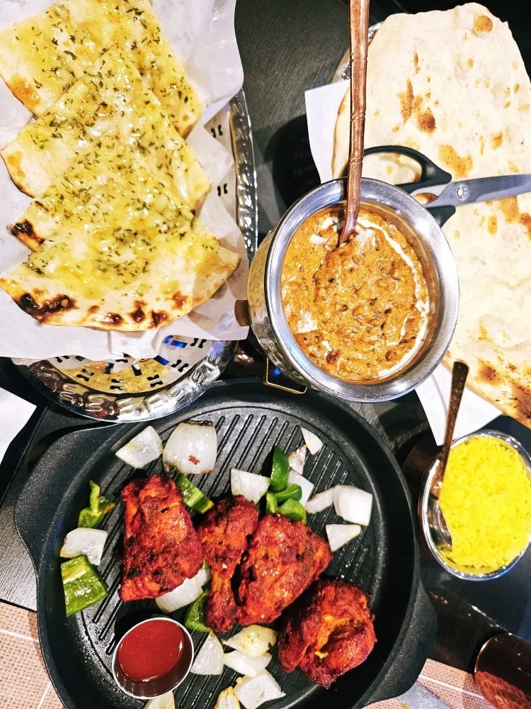 A full Indian meal spread with samosa, curry and naan