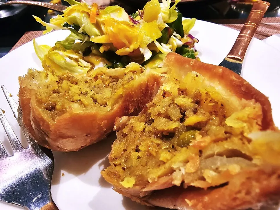 A cross-section of a samosa packed with filling
