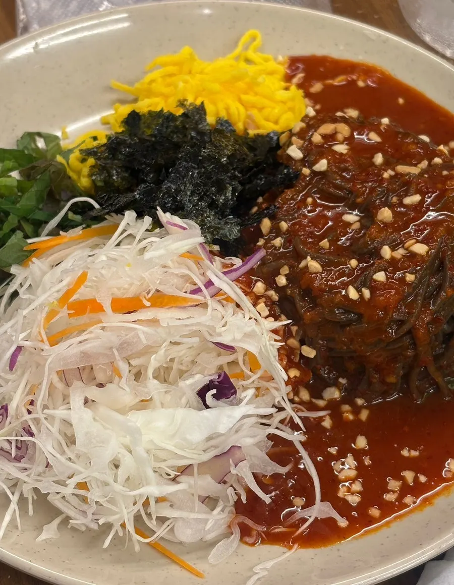 Platter mak-guksu topped with egg garnish and seaweed flakes