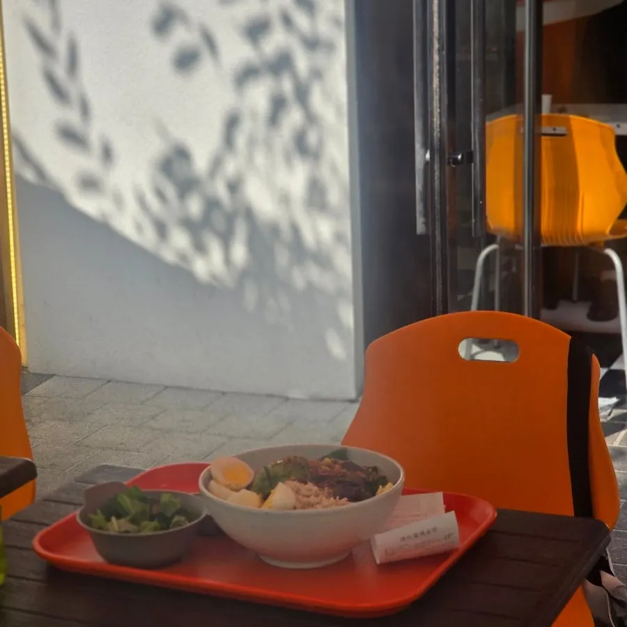 The terrace seating at Ola Poke Samseong Branch bathed in autumn sunlight
