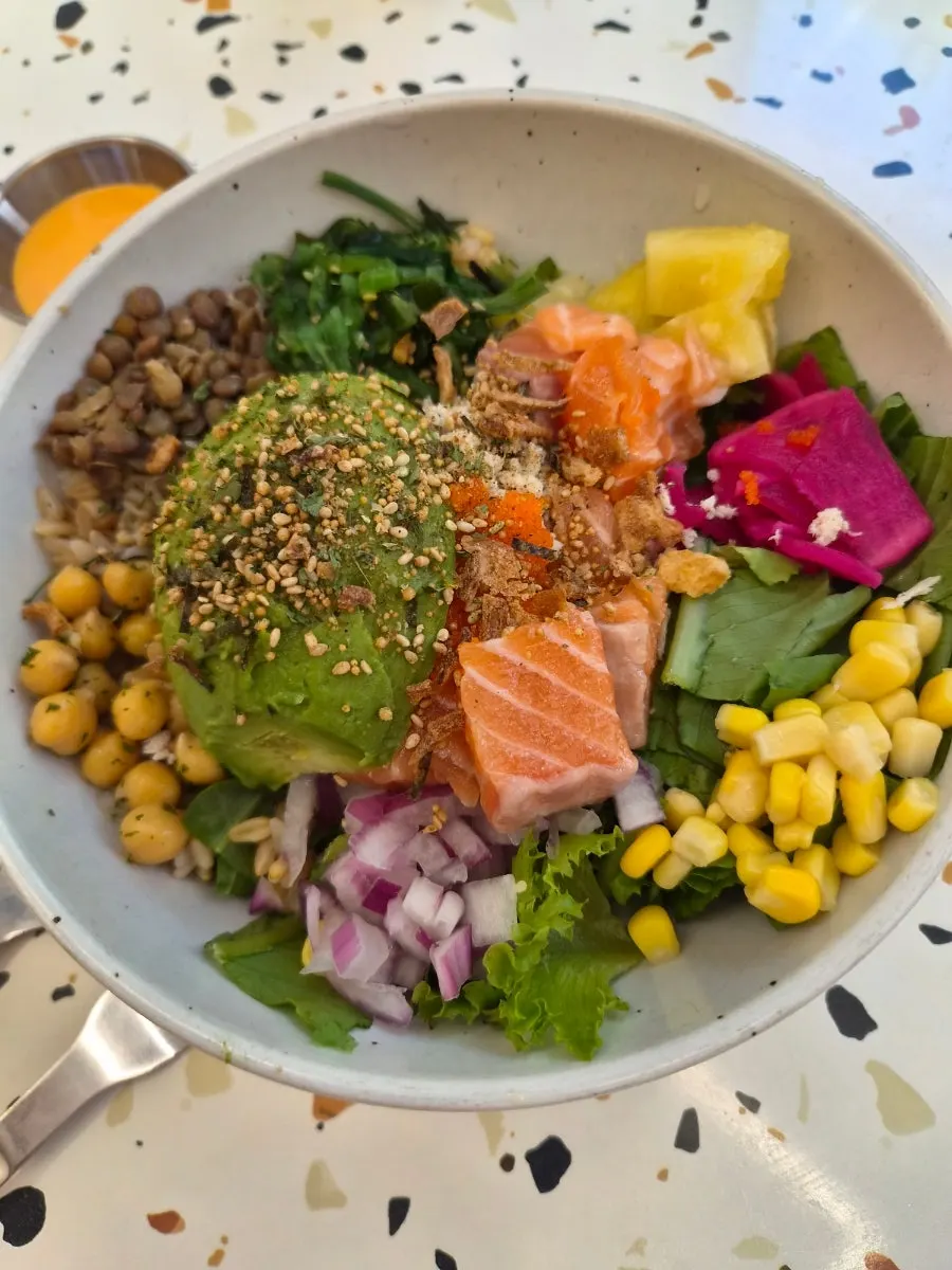 Poke bowl topped with salmon, corn and onion
