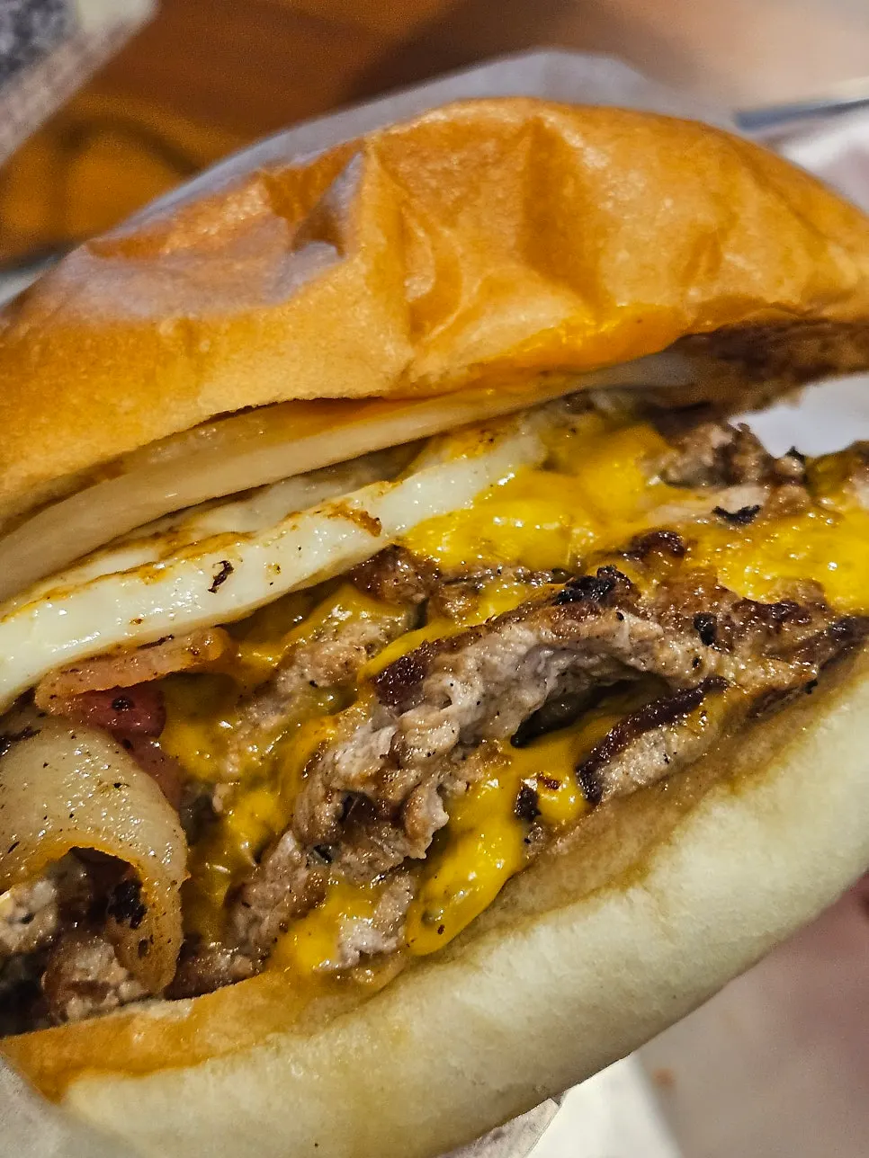 Handmade burger with brioche bun held in both hands