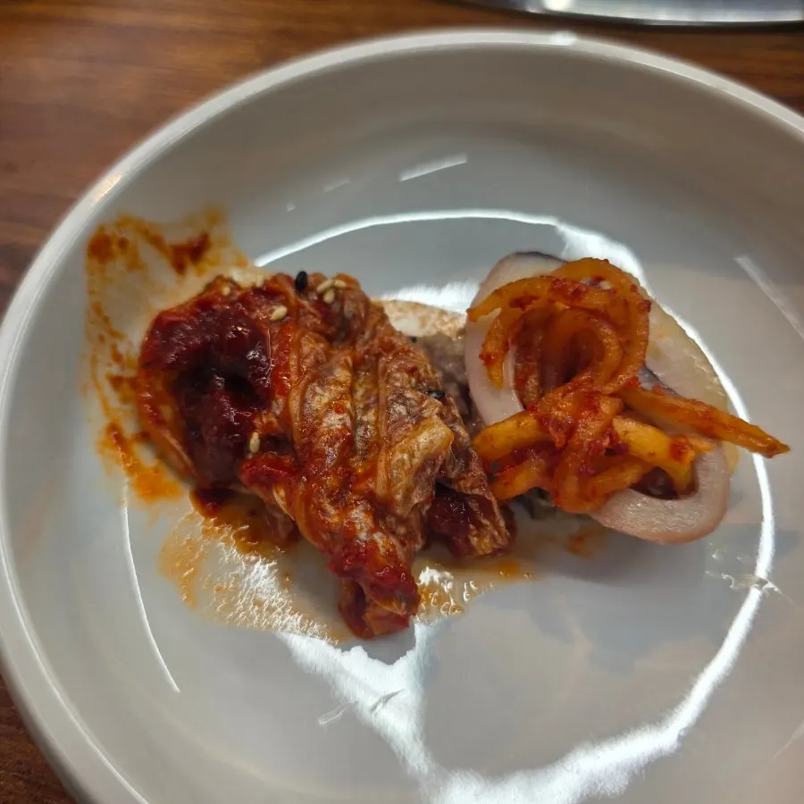 A bite wrapping kimchi, squid, and bossam together