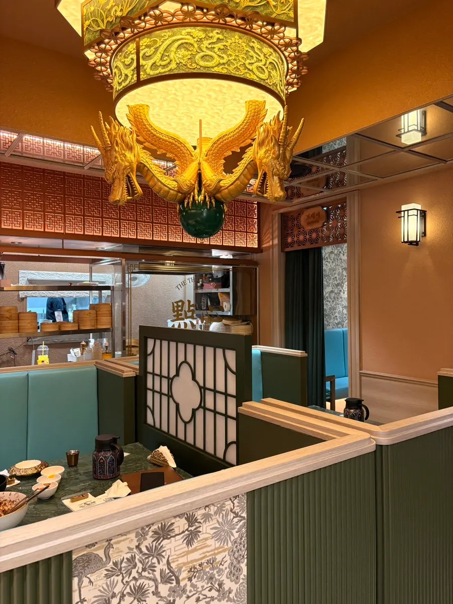 Golden dragon chandelier above the open kitchen marked with the character for dim sum