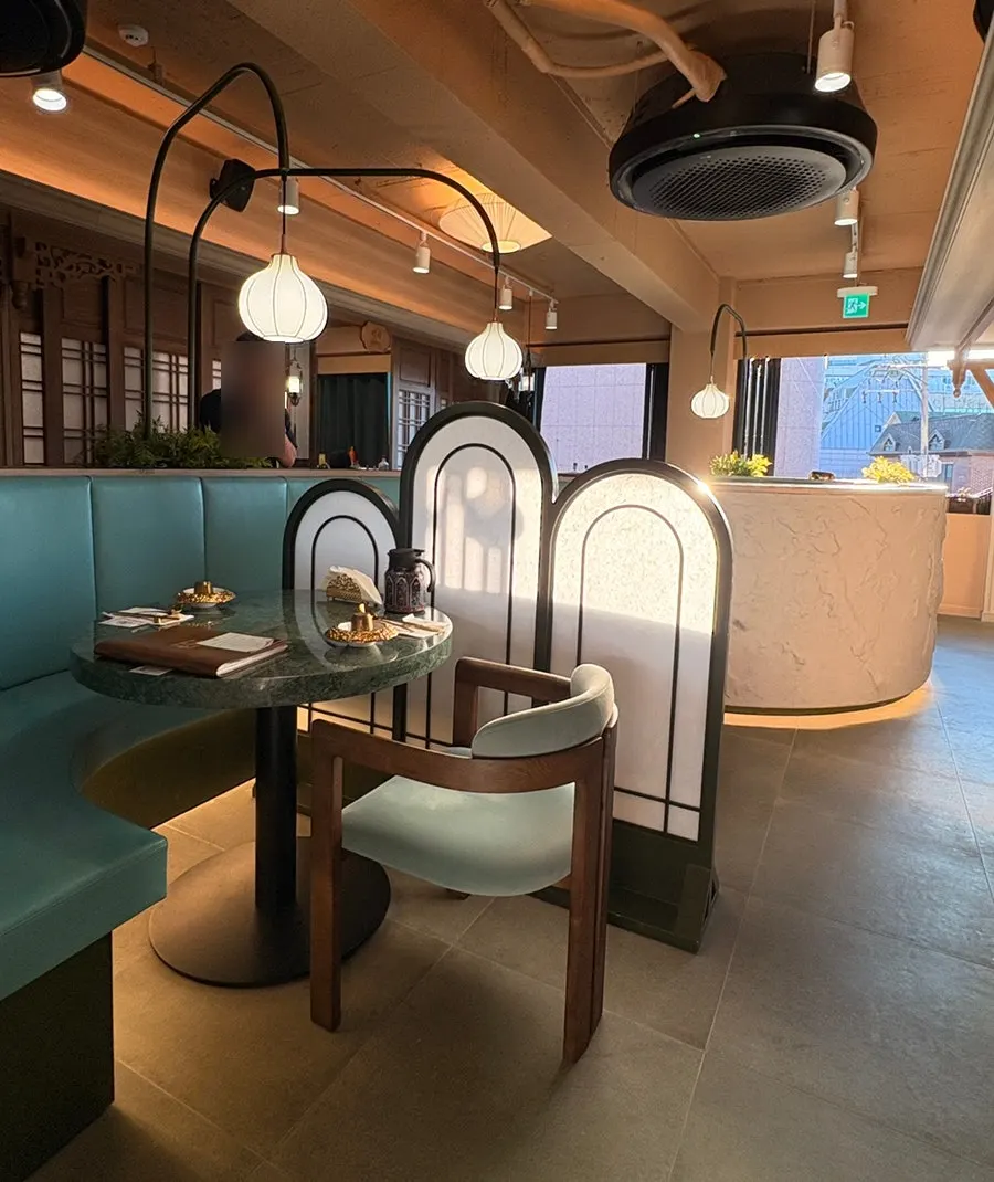 Window-side 2nd-floor hall with mint leather sofas and green marble tables