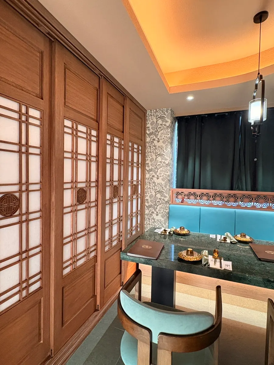 Room seating with framed Asian landscape paintings and indirect lighting