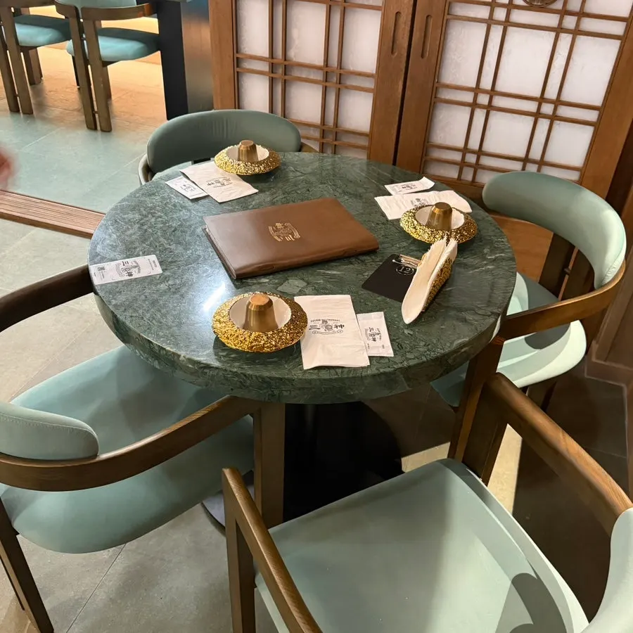 Dining hall interior mixing mint seating and wood tones