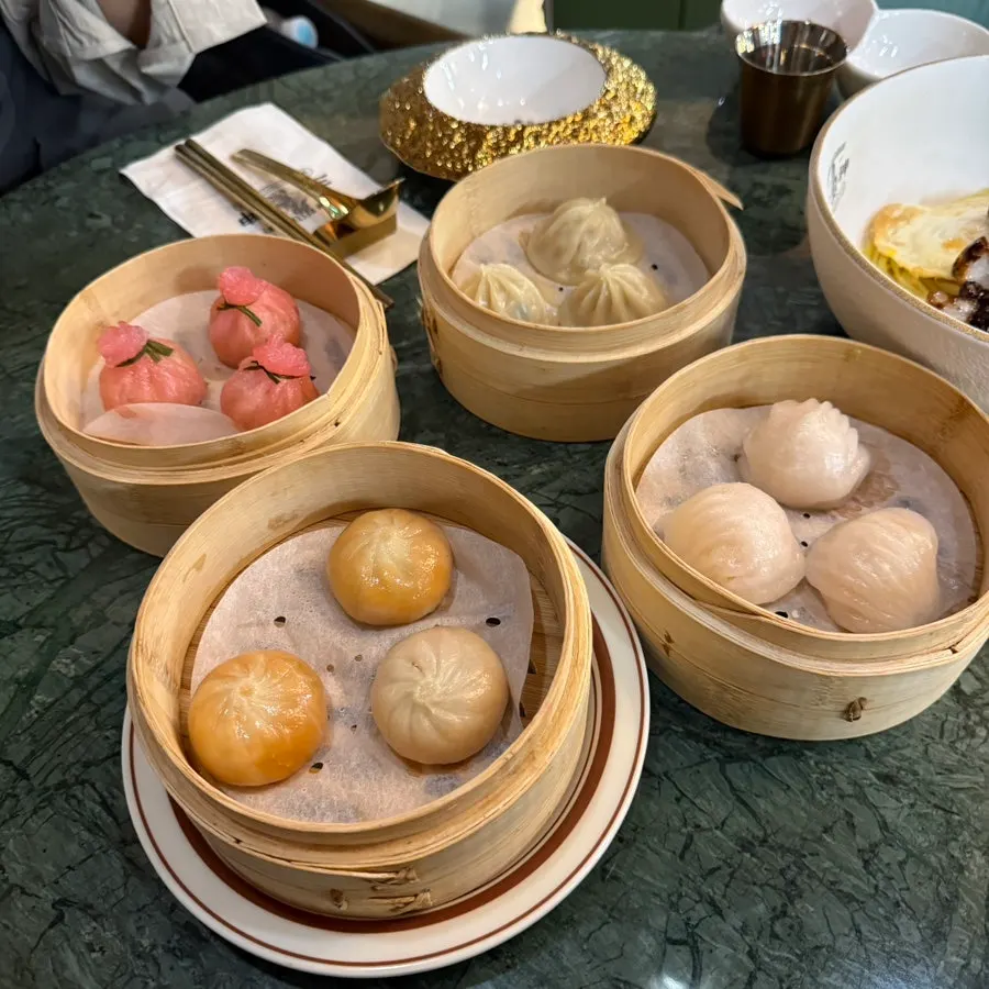 Table full of dim sum served in bamboo steamers