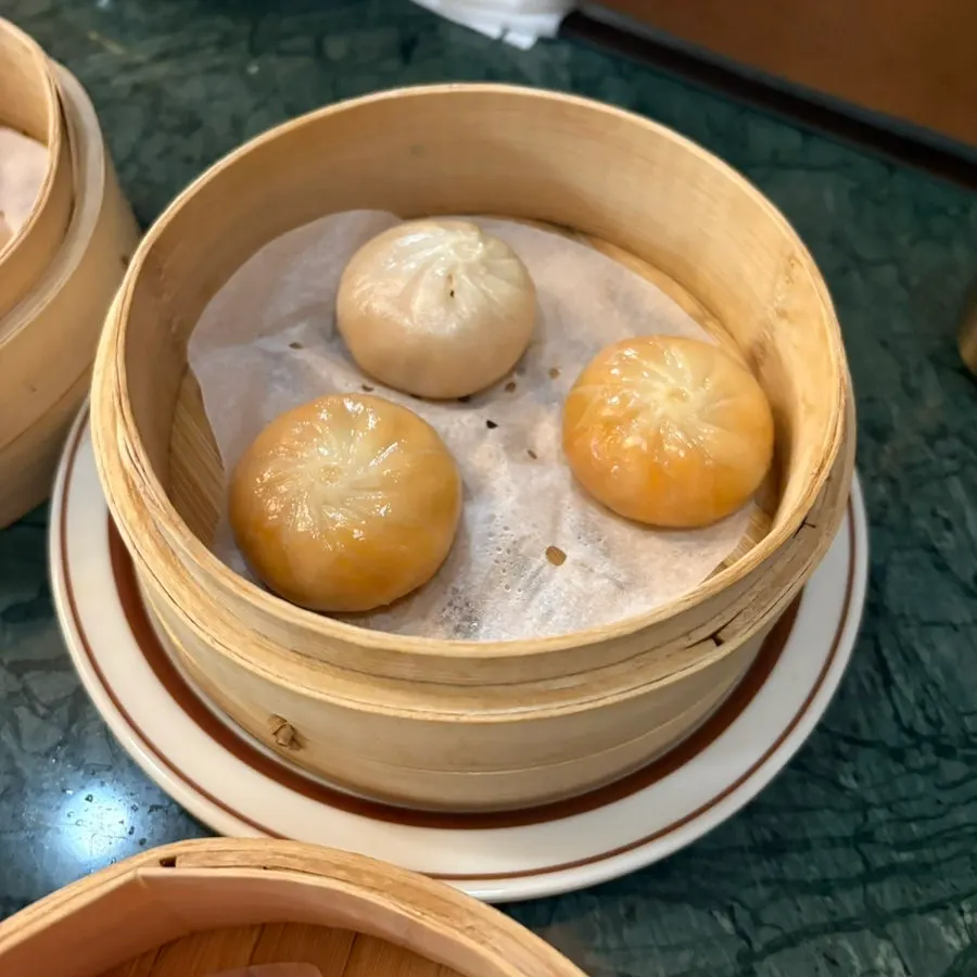 A bite-sized piece of wedding shaomai held up
