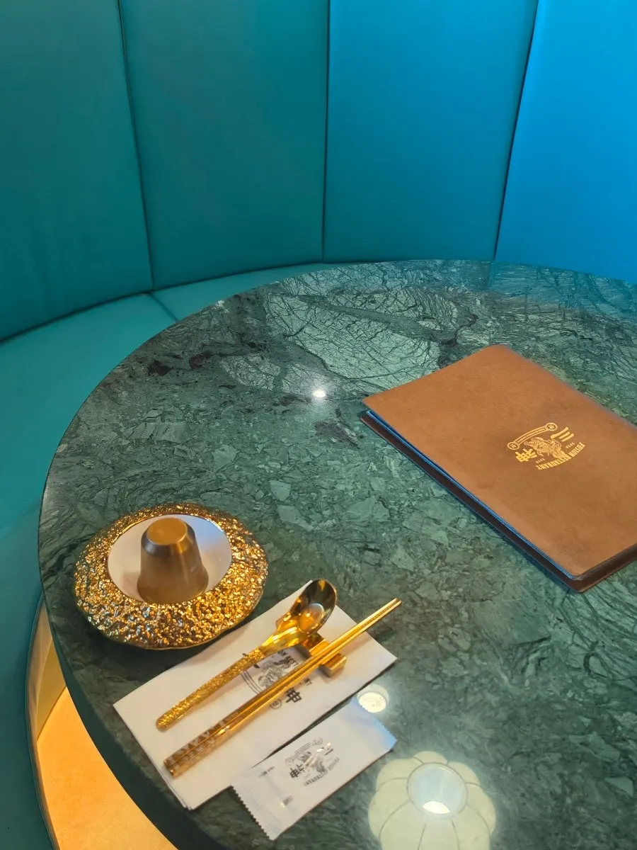 Mint-colored leather booths and green marble tables