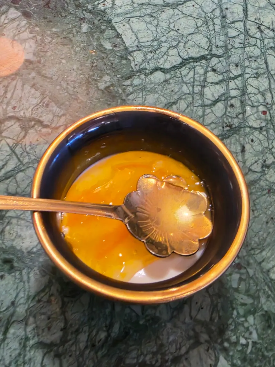 Orange-hued fruit dessert served in a ceramic bowl