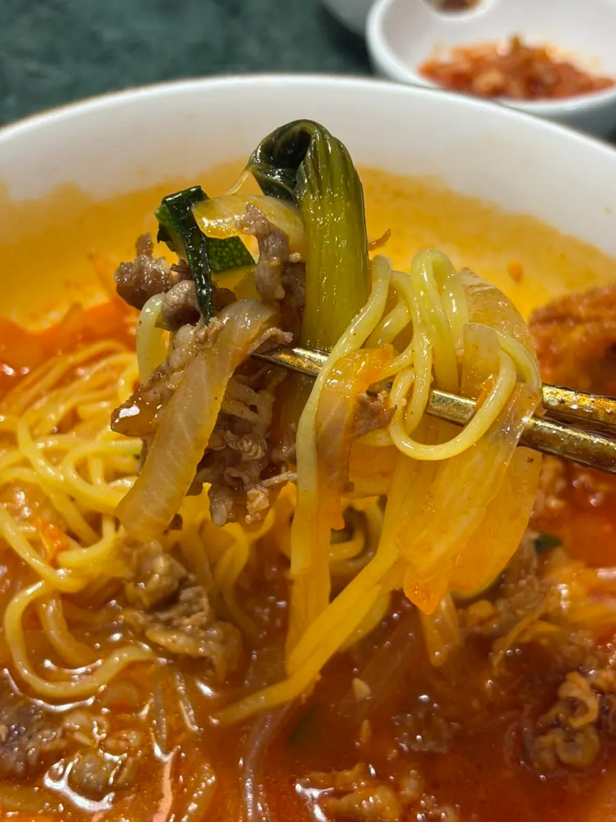 Fried chicken and noodles lifted together from the jjamppong