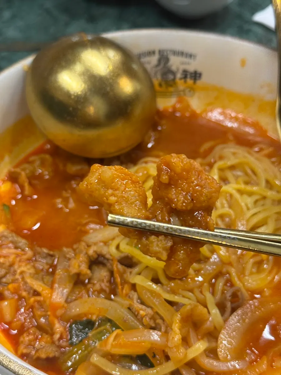 Noodles from the jjamppong lifted up with chopsticks