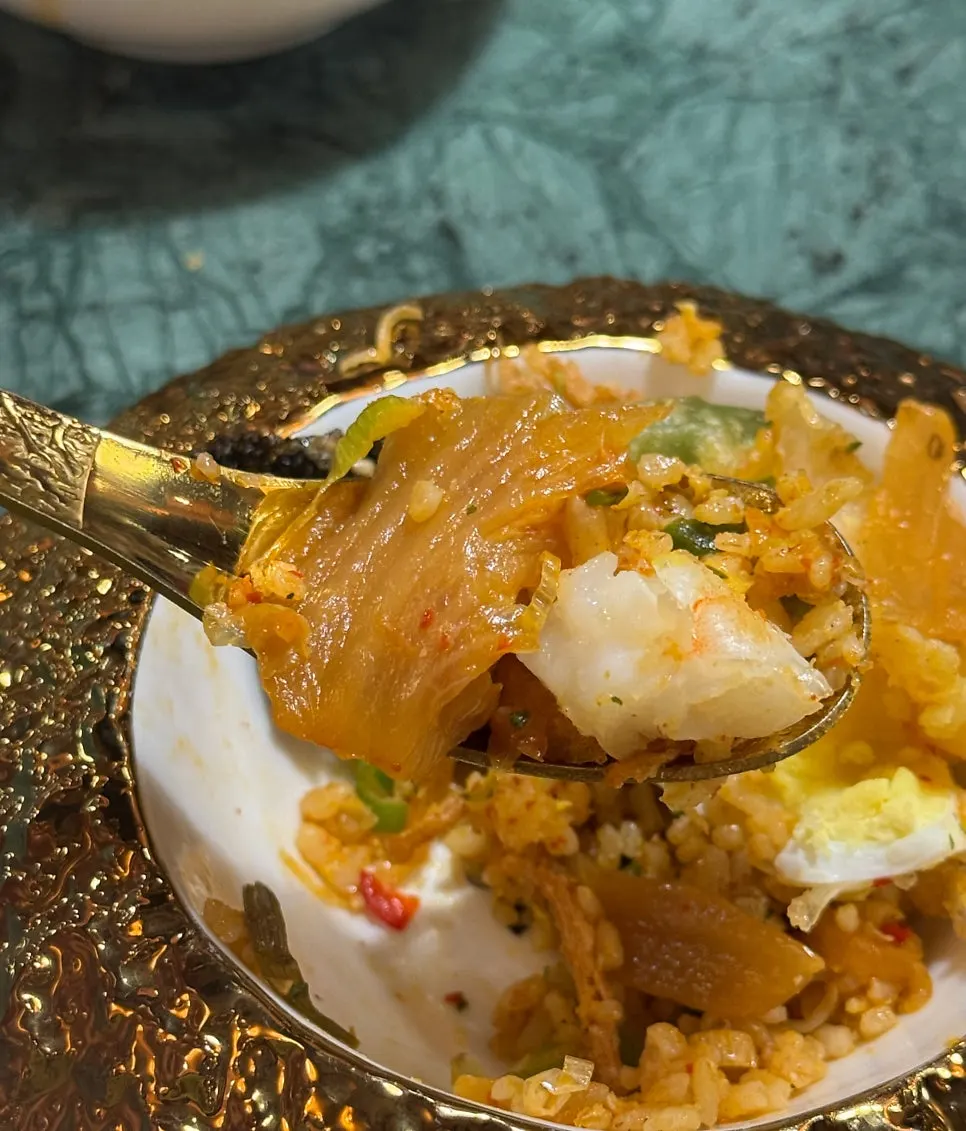 A bite of kimchi fried rice piled on gim-bugak