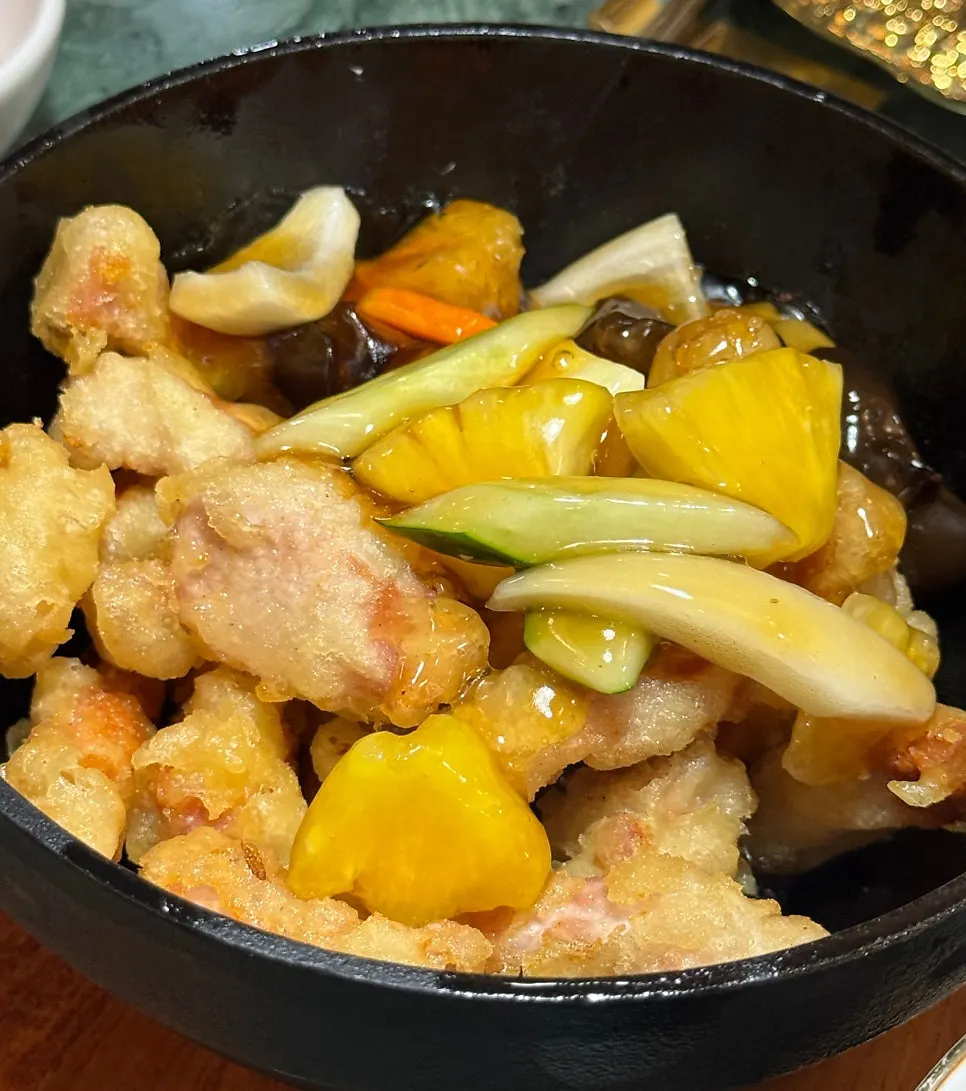 Broth from a xiaolongbao pooling on a spoon