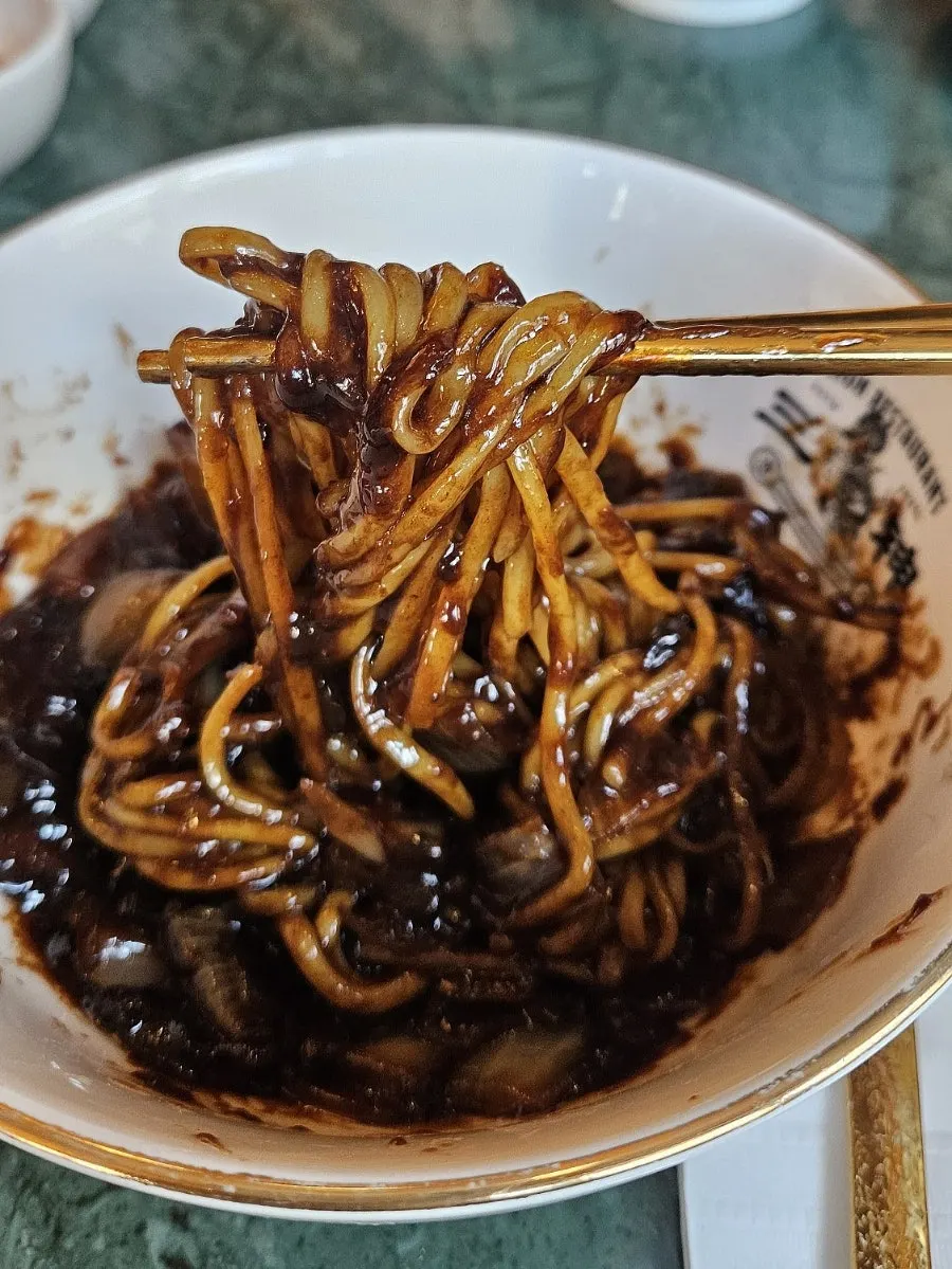 큼직한 감자가 들어간 짜장면 비빈 모습
