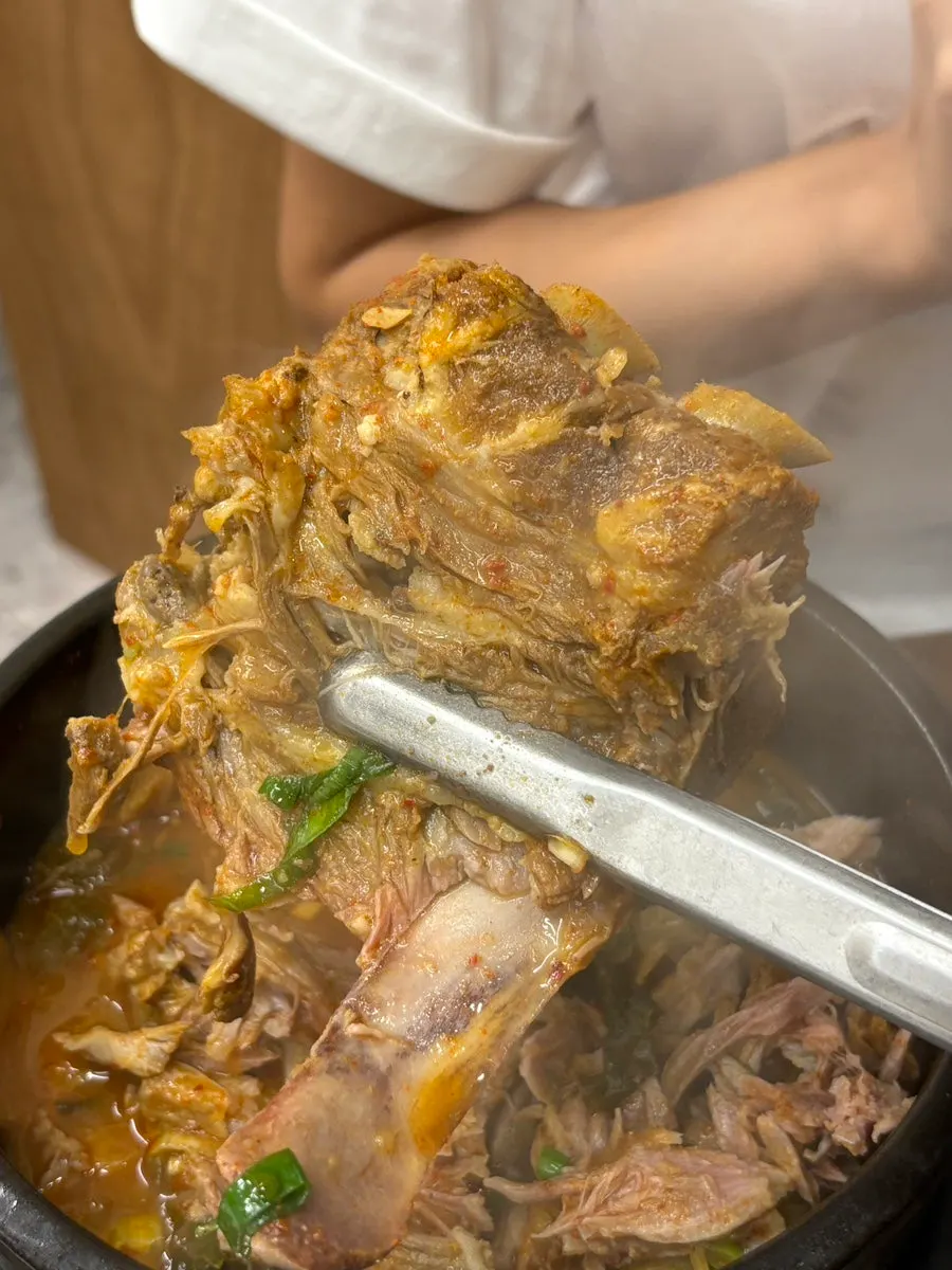 Meat being pulled off the bone in gamjatang