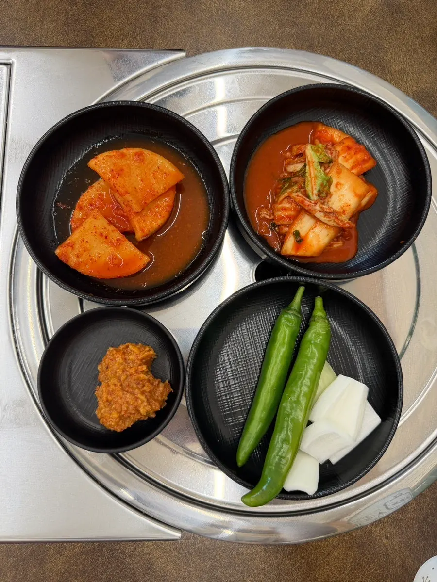 테이블 옆 수저와 일회용 앞치마