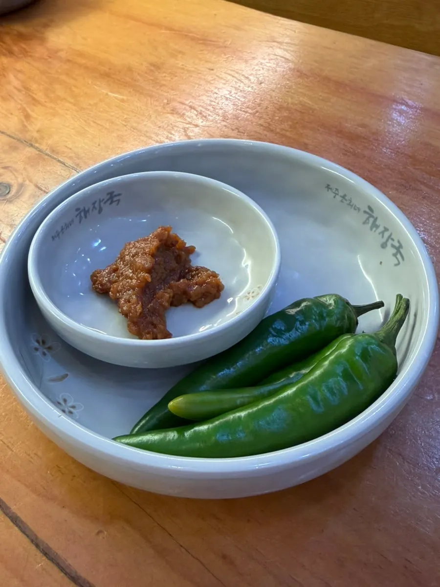 Basic side dishes of peppers, ssamjang, and pickled radish
