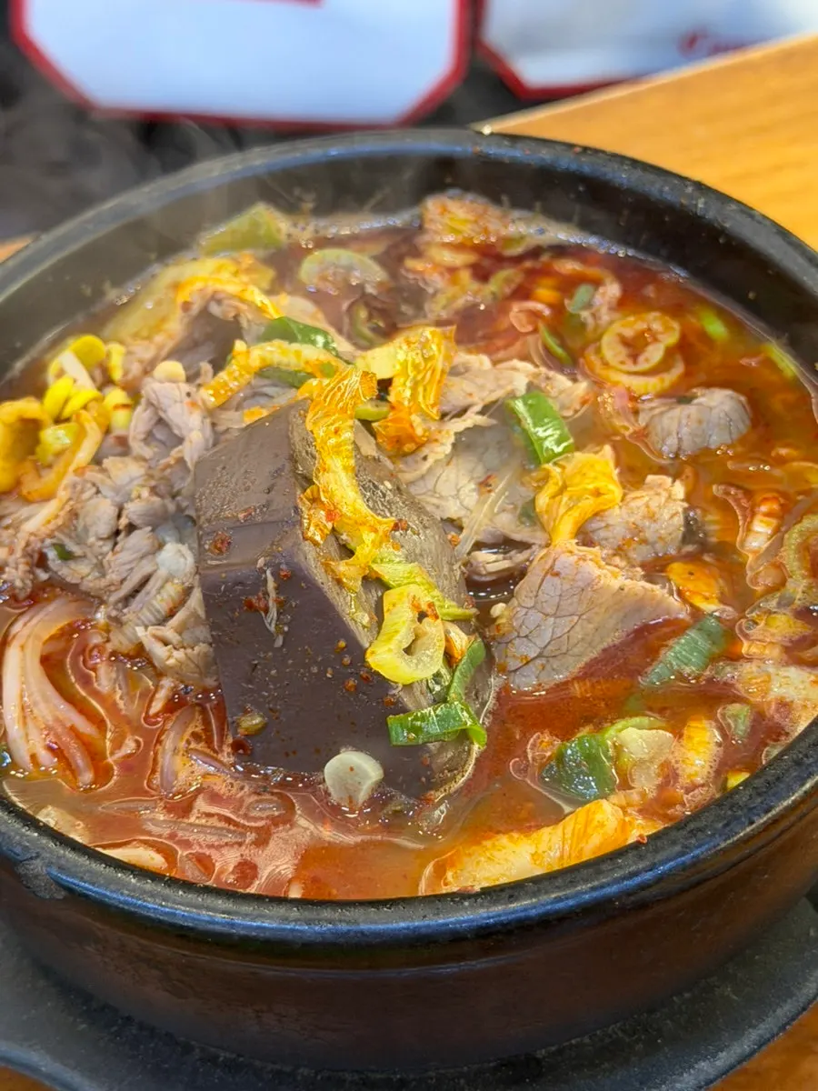 A bowl of haejangguk loaded with ingredients