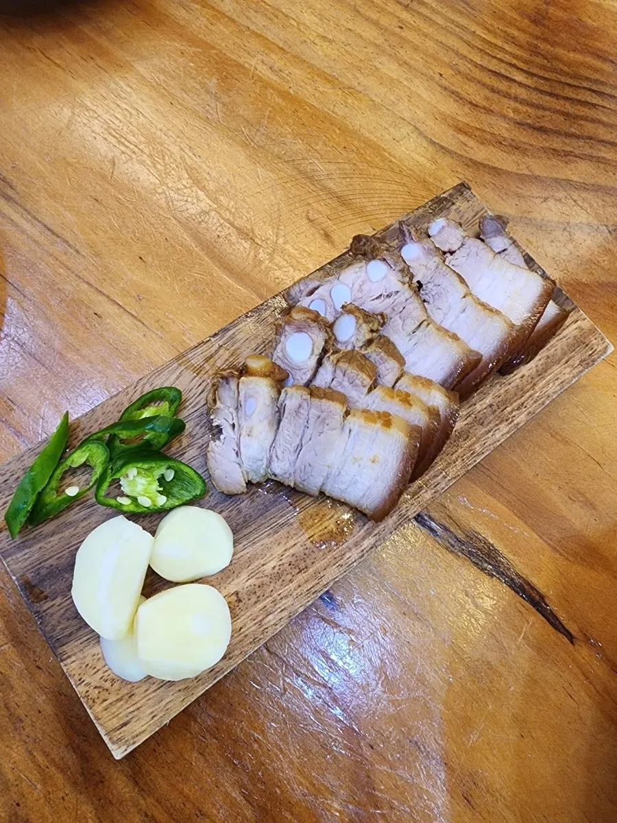 Dombe pork served on a wooden cutting board