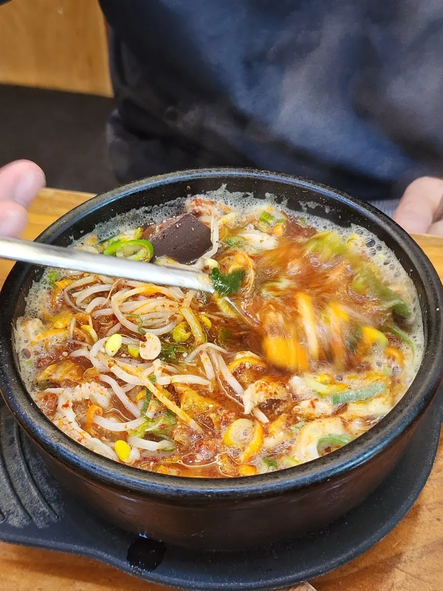 Meat and tripe lifted on a spoon from the soup