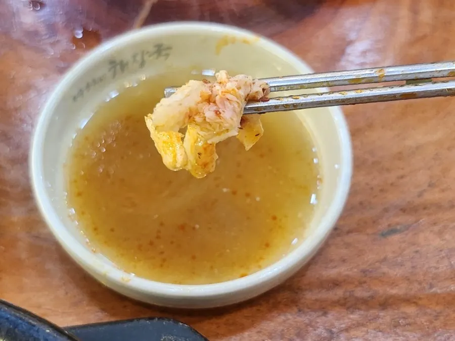 Spoonful of tripe soup ingredients lifted up