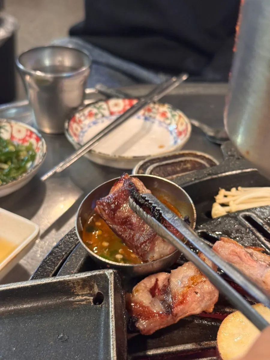 집게로 집은 다 익은 생갈비 한 점