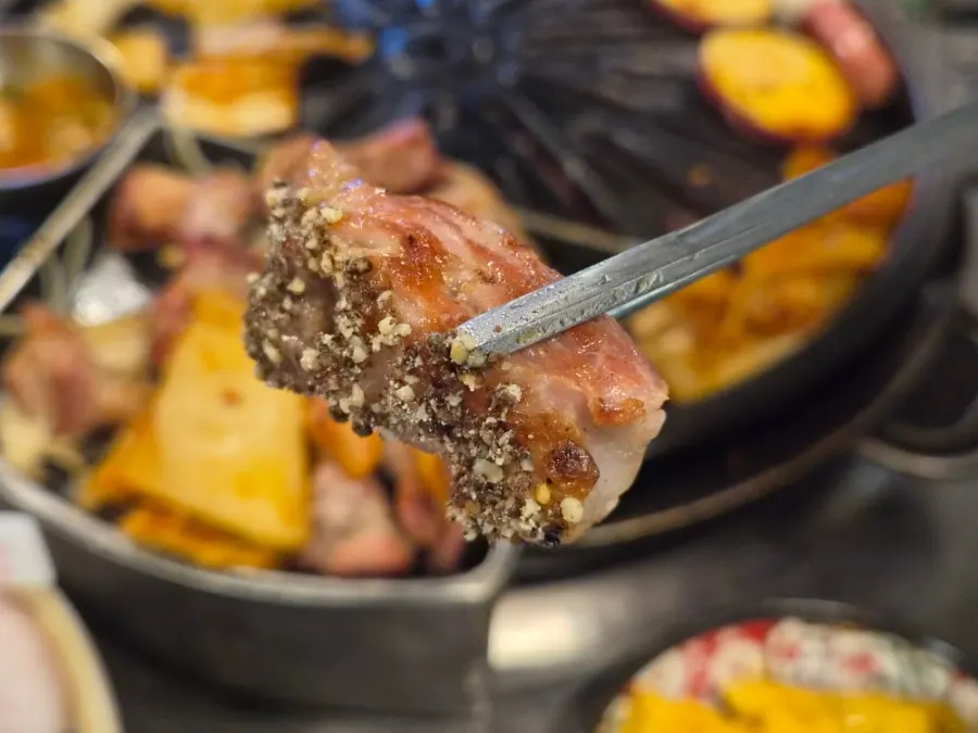 A piece of pork neck dipped in sesame oil and perilla powder