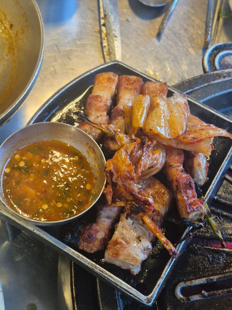 Pork belly sizzling on the grill