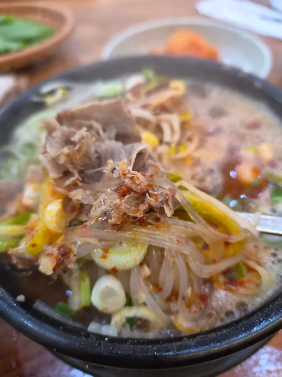 A spoonful of haejangguk ingredients lifted up