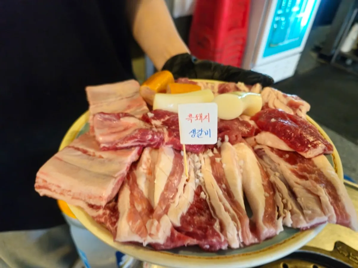 이불처럼 넓게 손질한 흑돼지 생갈비와 쌀떡, 소시지