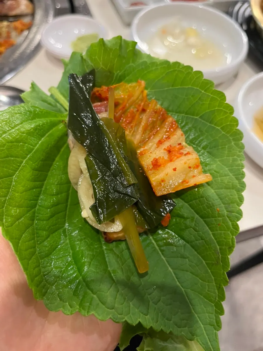 A piece of pork belly topped with grilled kimchi