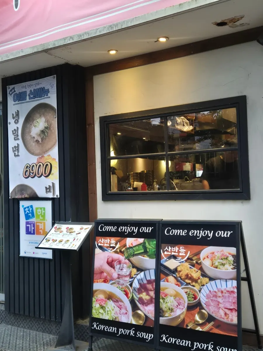Front of Sanbandeul Pork Gukbap with business hours posted