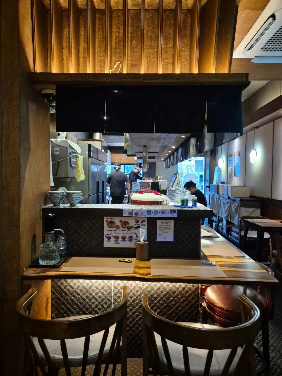 Interior of Sanbandeul Pork Gukbap with bar seating facing the open kitchen