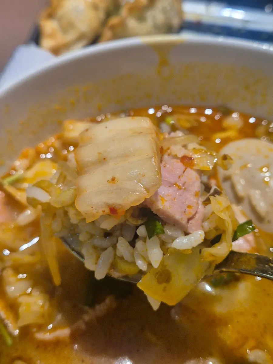 Broth of the spicy pork gukbap with rice mixed in