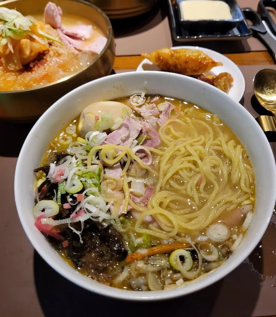 A bowl of Sanbandeul Pork Gukbap topped with noodles and egg