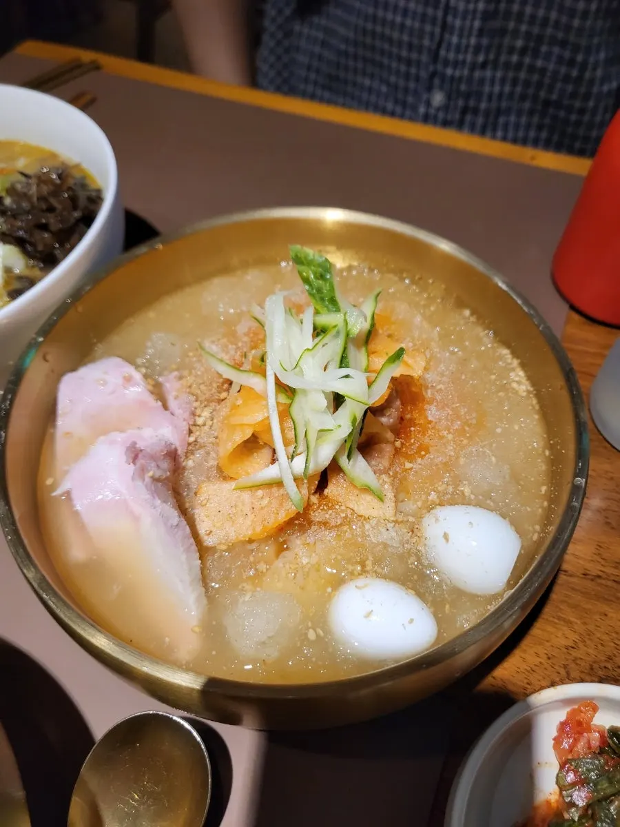 Close-up of the broth and meat in Sanbandeul Pork Gukbap
