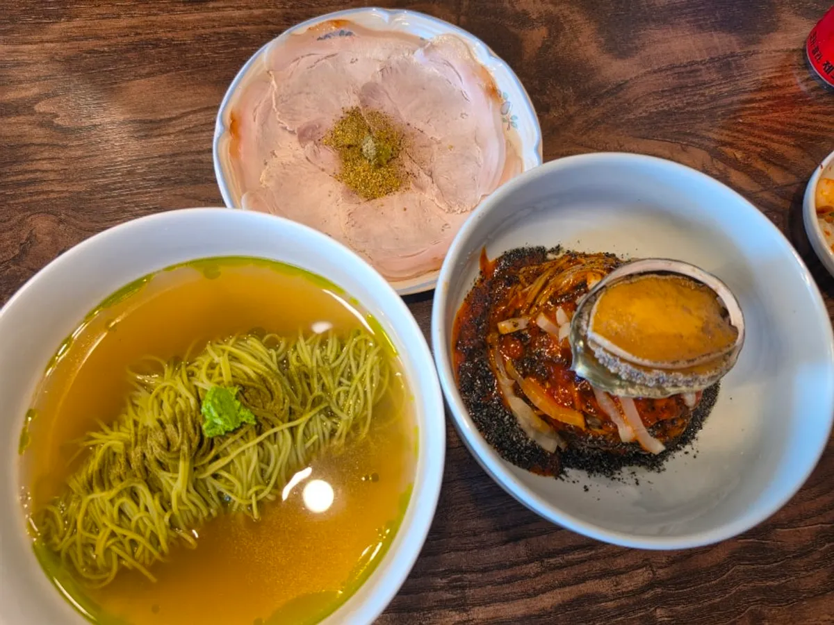A bowl of matcha onmyeon with green-colored noodles