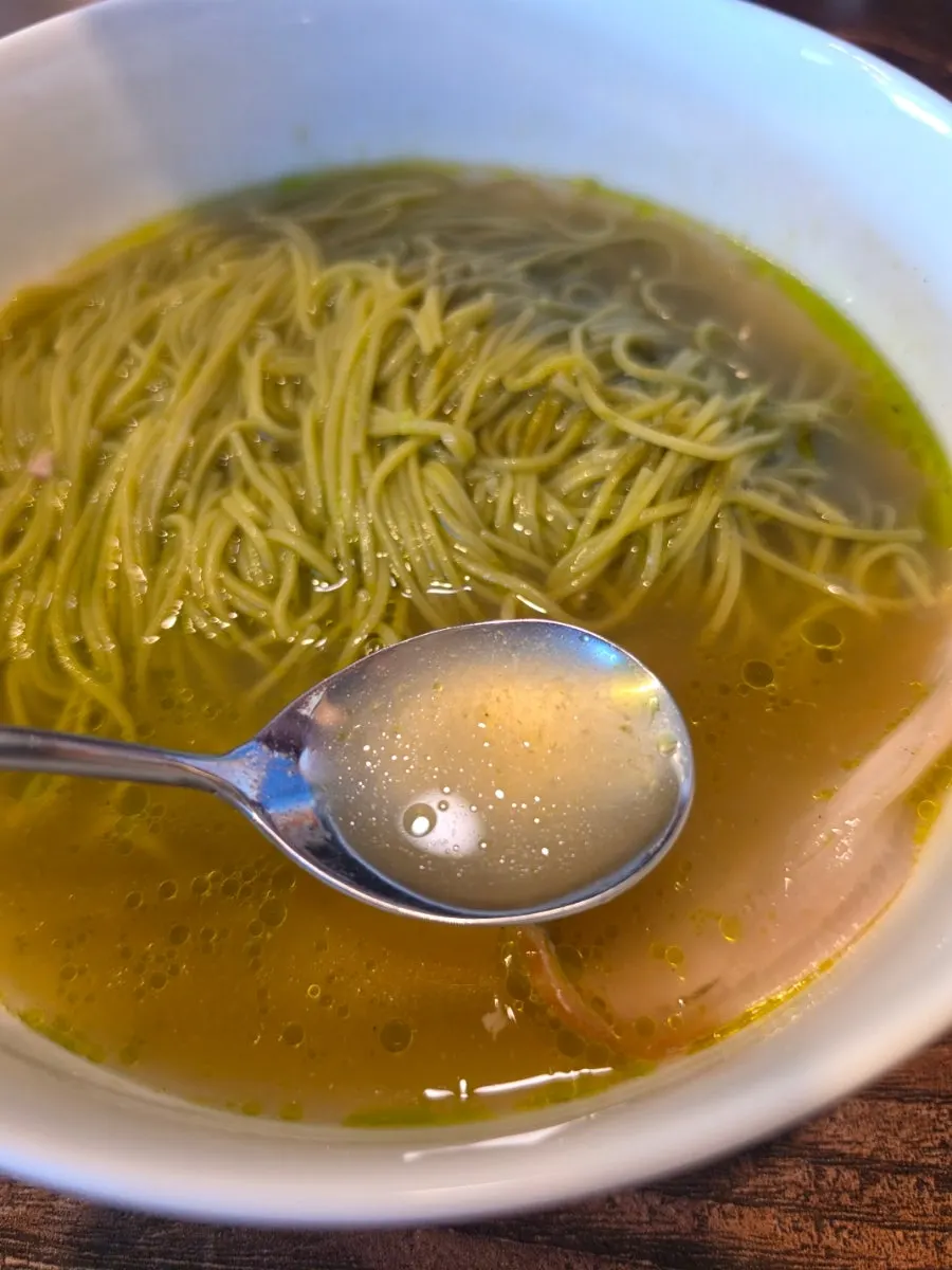 Lifting a strand of matcha onmyeon noodles